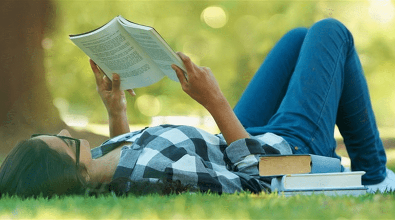 Женщина читает книгу на пляже летом