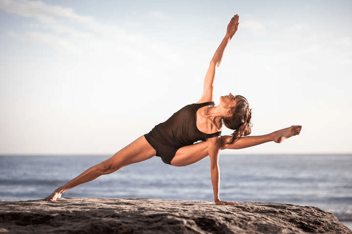 Женщина выполняет позу Кошки-Коровы